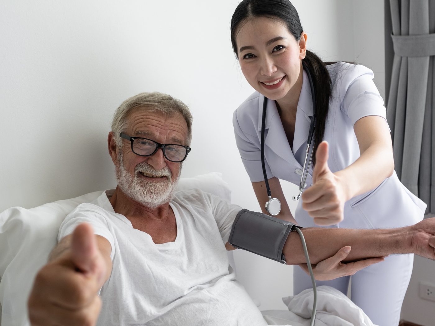 A nurse checking an older adult's blood pressure at home